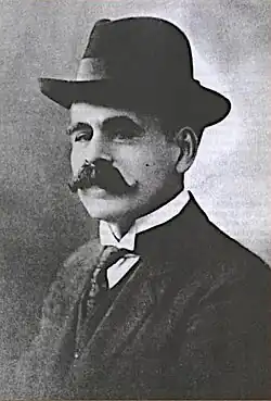 black-and-white profile image of Ángel Villoldo wearing a suit and hat, looking left at camera