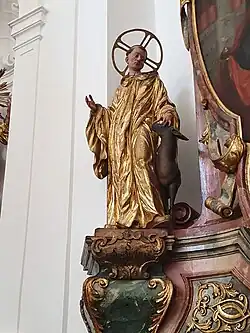 a statue of a small man in gold cloak