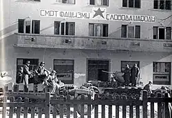 Shortly before Operation Kugelblitz, 11 November 1943 German troops of the 1. Gebirgs-Division mounted on (flak armed) half-tracks in front of the former partisan HQ (Hotel "Čajniče") in Tuzla after the city's capture. The partisan slogan "Death to fascism – freedom to the people" is written on the hotel facade.
