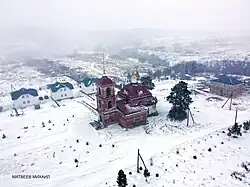 a lone red church in a snowy landscape