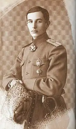 Head-and-shoulder photograph of a slender man with dark hair and moustache, dark suit and white-collar shirt