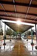 students seek shelter from rain under the solar energy plates