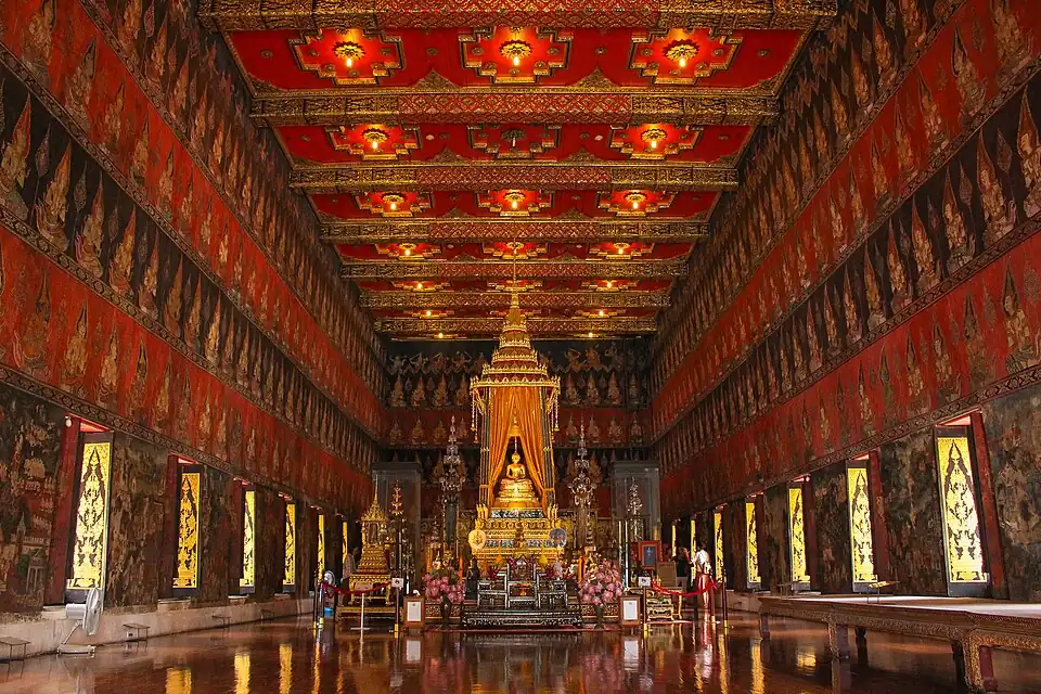 Interior of the Phutthaisawan Throne Hall in the Front Palace, showing the Phra Phuttha Sihing enshrined beneath a royal canopy, with early Rattanakosin-period court-style mural paintings on the walls.