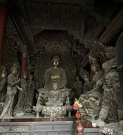 Liao dynasty statues of Mi Le Fo flanked by multiple attendant Bodhisattvas, with a smaller Buddha statue enshrined in front