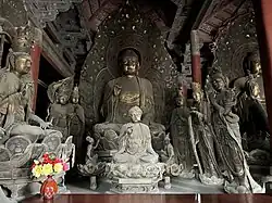 Liao dynasty statues of Randeng Fo flanked by multiple attendant Bodhisattvas, with a smaller Buddha statue enshrined in front