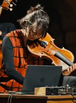 Strings arranger Atsuko Hatano performing on violin at a 2025 concert
