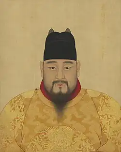 Emperor Yingzong wears a yellow robe and a black cap.