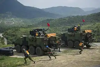 Military troops exiting Armored Personnel Carrier vehicles