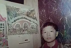 Teng standing in front of his artwork in 1975