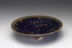 Black-glazed tea bowl with "partridge feather" splashes (zhegu ban 鷓鴣斑), Song dynasty (960–1279), Jizhou ware. National Palace Museum.