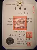 The national, presidential, and a ministerial seal seen on a certificate awarding the Order of Merit for National Foundation