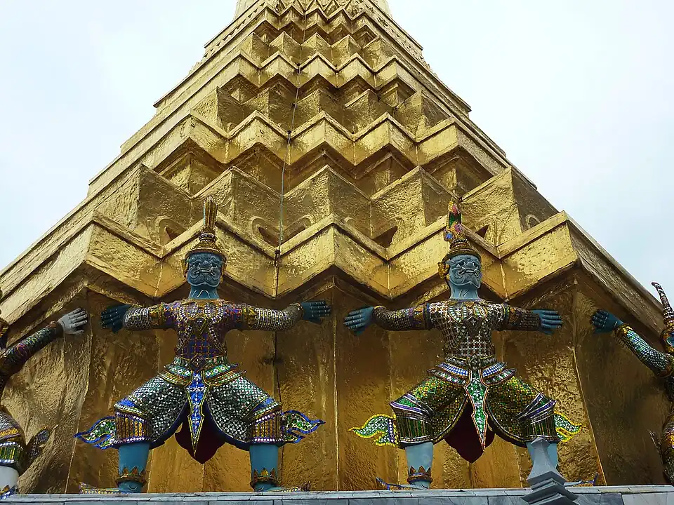 Detail of one of the golden chedi, showing the supporting giants around the base