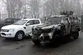 A KrAZ Cougar parked next to a Ford pickup truck.