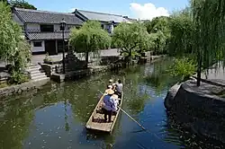 White houses with roof tiling next to a small channel.