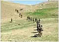 Members of the 8th Commando Kandak and coalition Special Operations Forces patrol though a valley near Nawa Garay village, Kajran district, 2012.