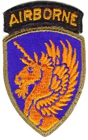 A shoulder patch of an army airborne division depicting an orange unicorn on a blue background