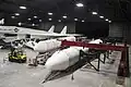 Two SRMU rockets lay horizontally next to an XB-70 bomber.