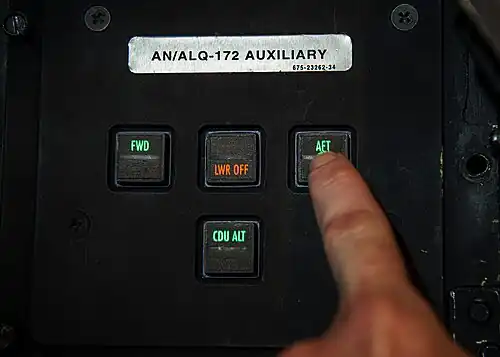 Electronic warfare officer, pushes a hard-wired power switch for ALQ-172 auxiliary