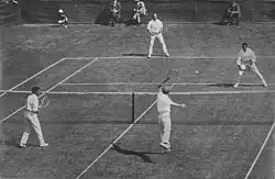 1912 International Lawn Tennis Challenge (Davis Cup) finals match between Australasia and the British Isles played at the Albert Ground in Melbourne, Australia on 28–30 November. Players shown on the near side are Alfred Dunlop (left) and Norman Brookes (right) for Australasia and on the far side James Cecil Parke (left) and Alfred Beamish (right) for the British Isles.