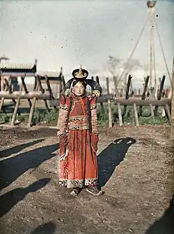 1913 photo of Mongol woman next to the Khais (hedge fence) of Zuun Khuree.