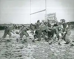 Black and white photo of people playing football on a field