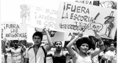 March in Cuba condemning Mariel emigrants. The sign the foreground reads "away with the filth!" and depicts the Marielitos as a gusano fawning at the feet of Uncle Sam.
