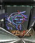 Artwork depicting Ramses Shaffy over the southern escalators