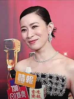 Charmaine Sheh being interviewed by reporters, with several microphones in front of her