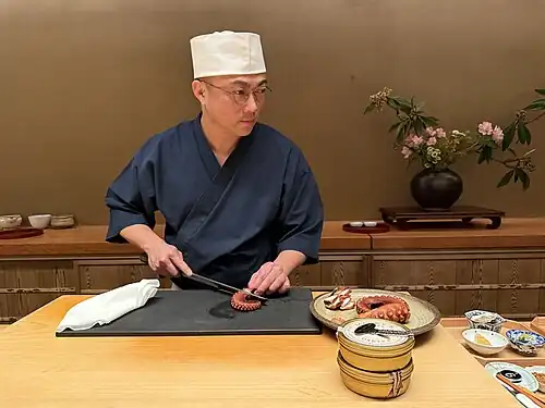 Chef slices octopus.