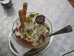 Ice cream garnished with pistachio pieces and rolled wafers