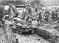 Men carrying mortar bombs by their attached carrying straps