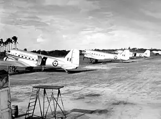 Black and white photograph of five silver aircraft parked in a line