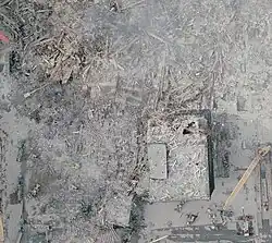 Site of 4 WTC in NOAA aerial image, oriented with south at left of image (September 23, 2001). Much of 4 WTC is destroyed (entire left of image), with only the damaged northern portion identifiable (at right).