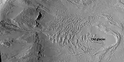Glacier on a crater floor, as seen by HiRISE under HiWish program The cracks in the glacier may be crevasses. There is also a gully system on the crater wall. Location is Casius quadrangle.