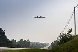 An A-10 Thunderbolt II from Selfridge Air National Guard Base, Michigan, flying over a public highway in Alpena, Michigan, August 5, 2021