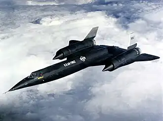 A black aircraft in midair