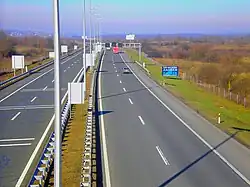 A view of the motorway from a flyover, a variable traffic sign gantry is visible