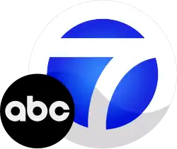 A white circle and bold 7 with blue background, with the ABC logo sitting atop it in the lower left corner