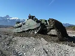 This AEV 3 Kodiak is using its front-mounted blade for dozing.