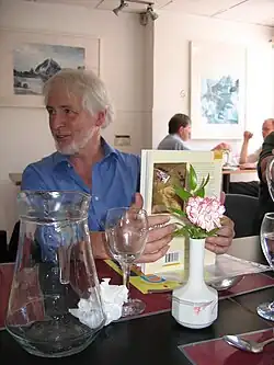 Man seated in restaurant holding a book