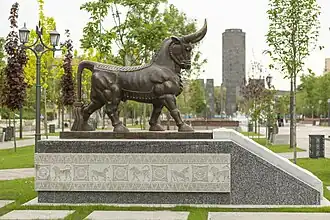 A bronze bull statue is installed at the entrance of the park