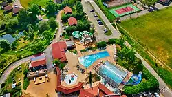 A drone-captured aerial photograph showing a swimming pool, water slides, surrounding buildings, and outdoor leisure areas