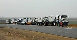 TII Nicolas Tractomas ballast tractors pulling a hydraulic modular trailer with girder bridge.