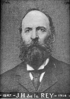 Portrait photograph of a middle aged Caucasia male in a suit. He has a full beard and moustache. The inscription below the image includes his name and his date of birth and death.