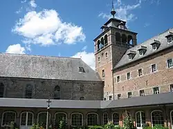 Le cloître de l'abbaye de Leffe et, à son angle, la tour clocher (photographie moderne).