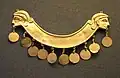 Elongated breast ornament with human heads at both ends
