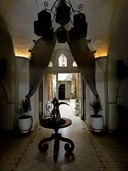 Interior with table, chandelier, and curtains; 2011