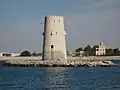 Al-Maqta' Tower (Arabic: بُرْج ٱلْمَقْطَع, romanized: Burj Al-Maqṭaʿ; front) and Al-Maqta' Fort (Arabic: حُصْن ٱلْمَقْطَع, romanized: Ḥuṣn Al-Maqṭaʿ; back), just outside the island of Abu Dhabi