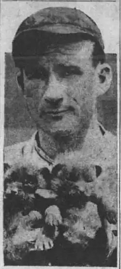 Alabama Pitts in a baseball uniform holding two cub team mascots