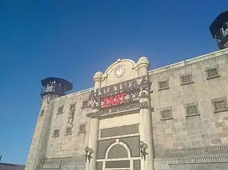 Prison wall with guard towers and large sing